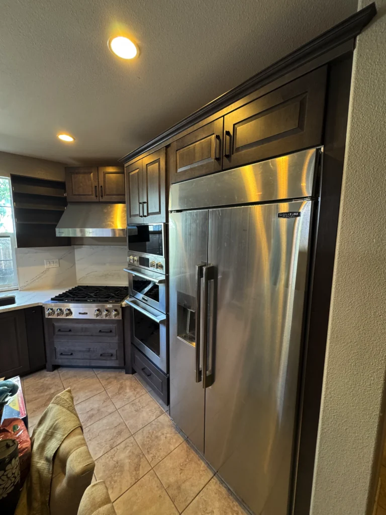 dark wood raised panel cabinets with quartz slab backsplash