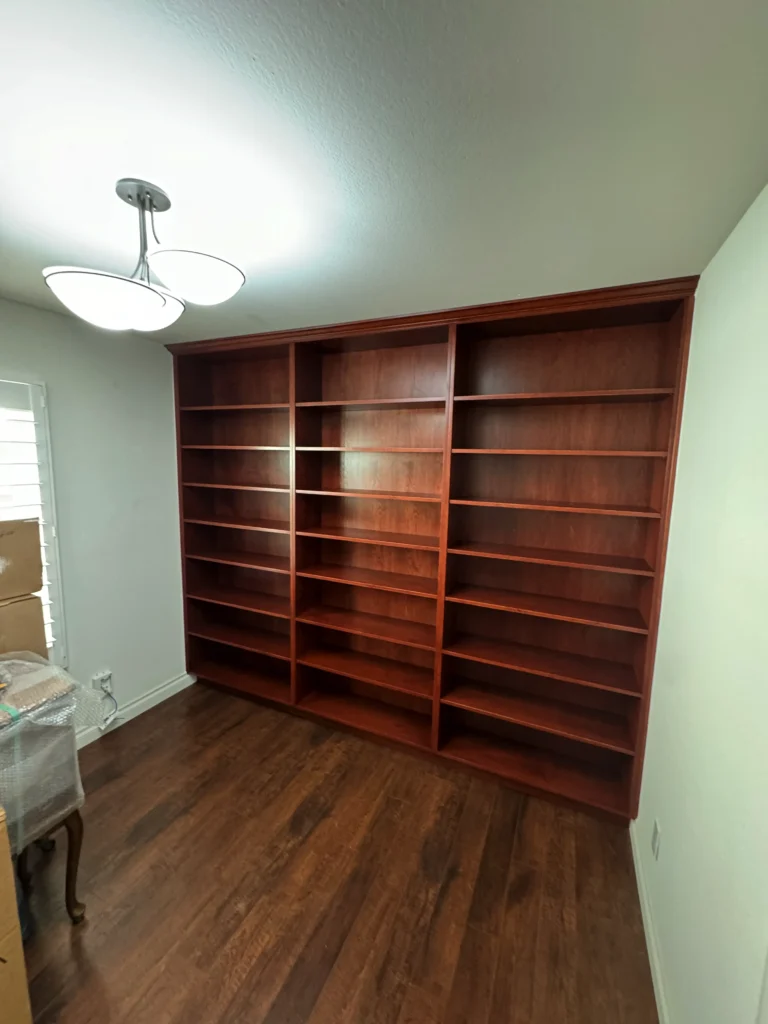 traditional home library with adjustable shelves and crown molding