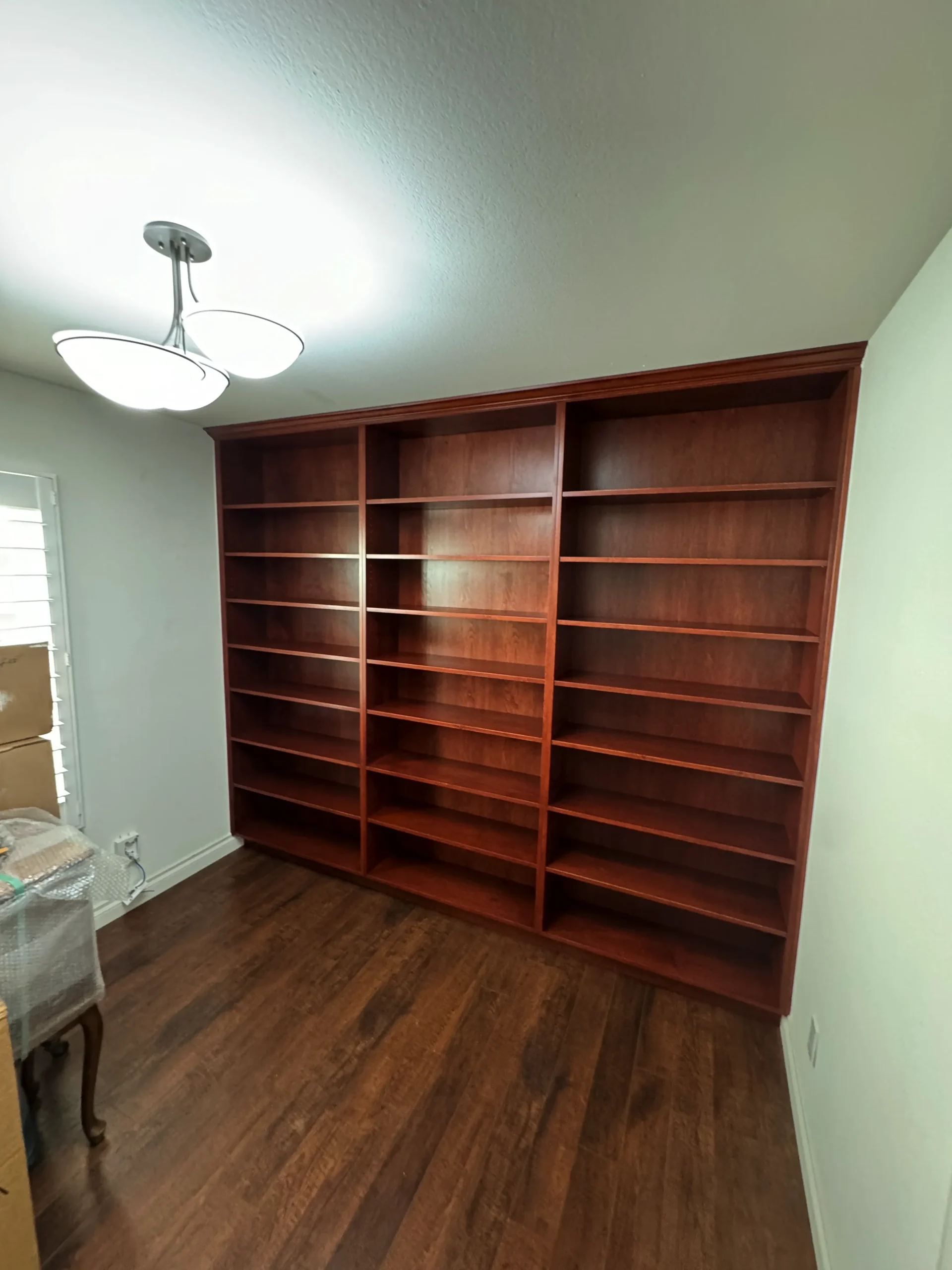 traditional home library with adjustable shelves and crown molding