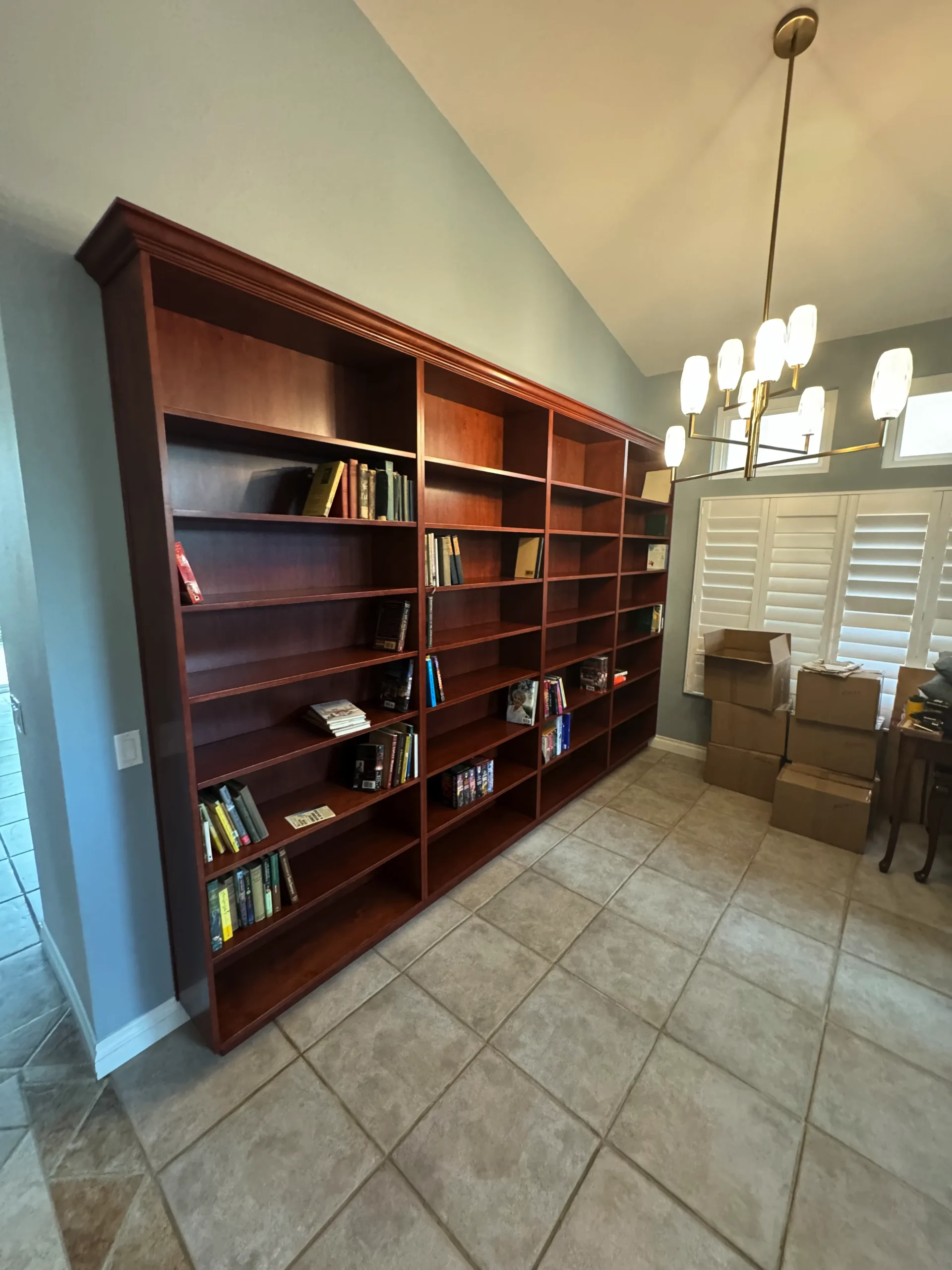 traditional home library with adjustable shelves and crown molding