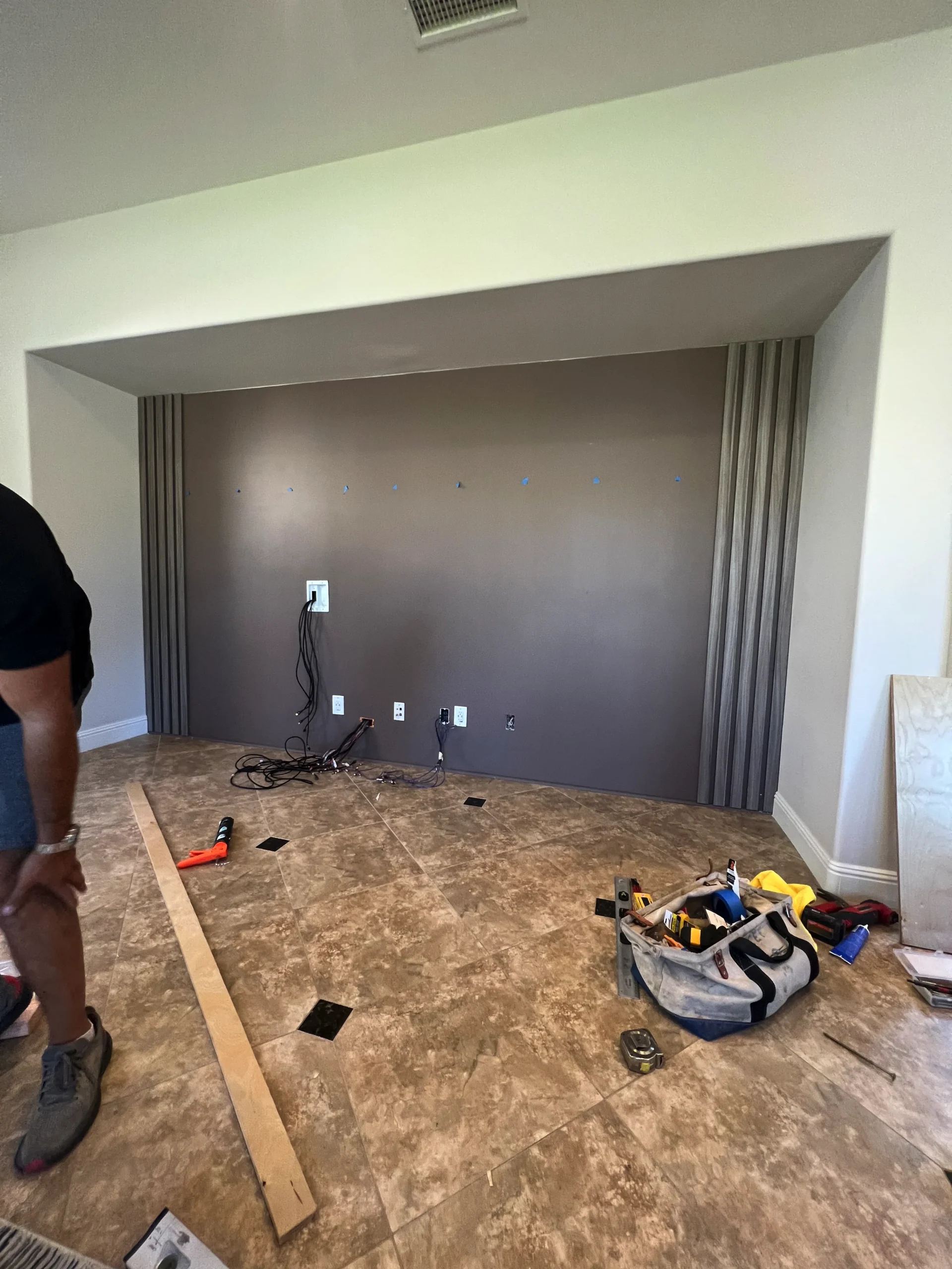 living room with fluted panels and a marble-look TV backer