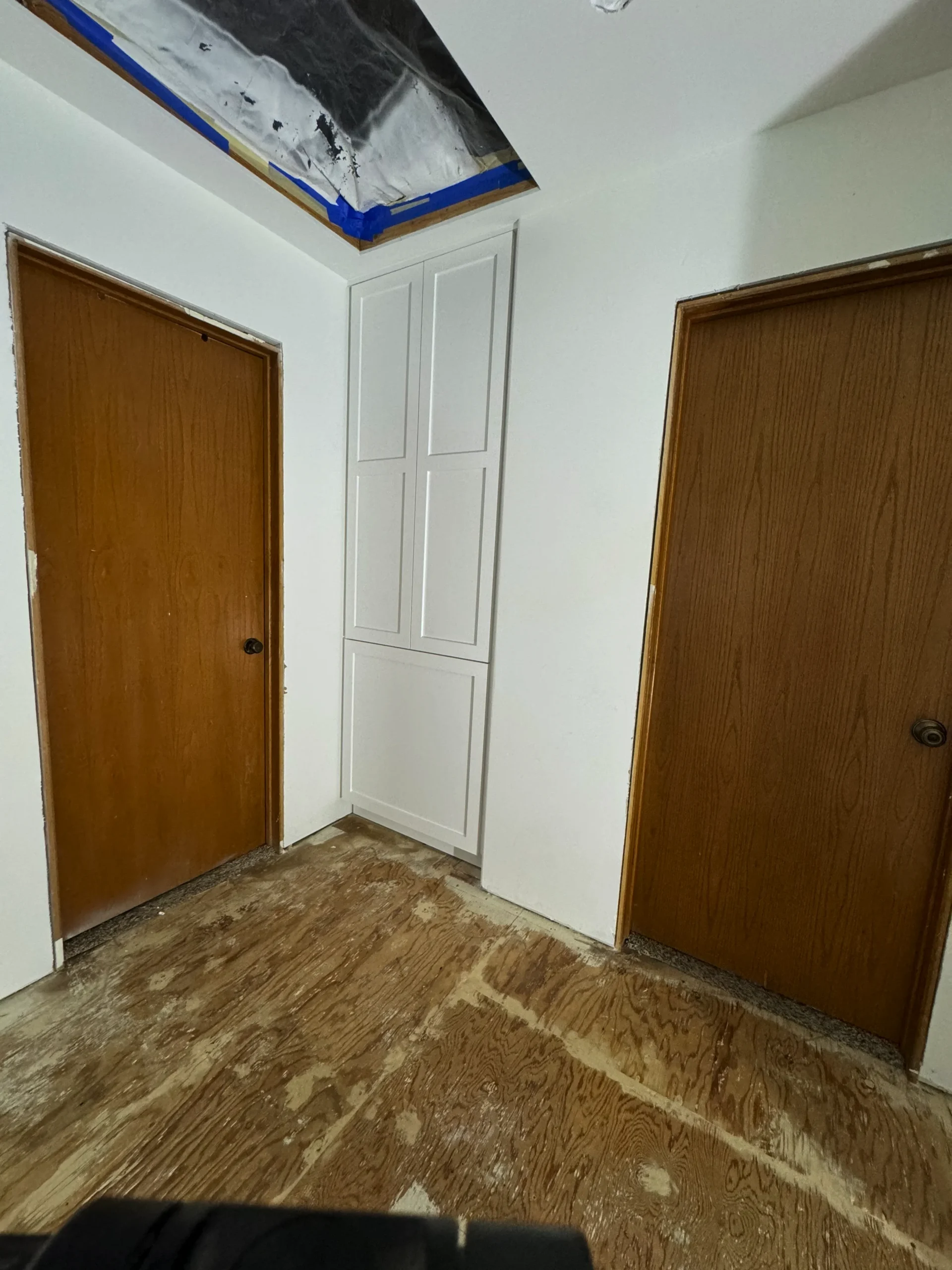built-in concealed laundry hamper with a white shaker front