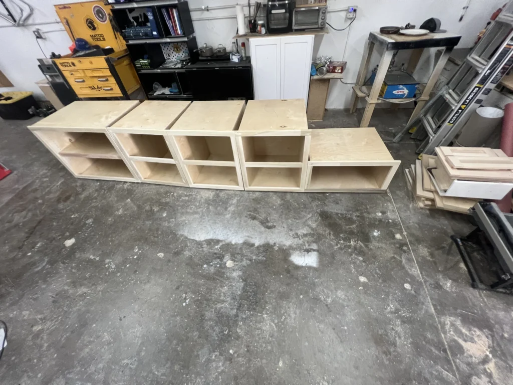 light grey shaker cabinets with a white oak desktop and brass hardware