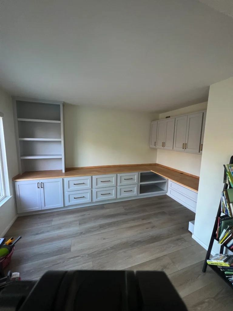 light grey shaker cabinets with a white oak desktop and brass hardware
