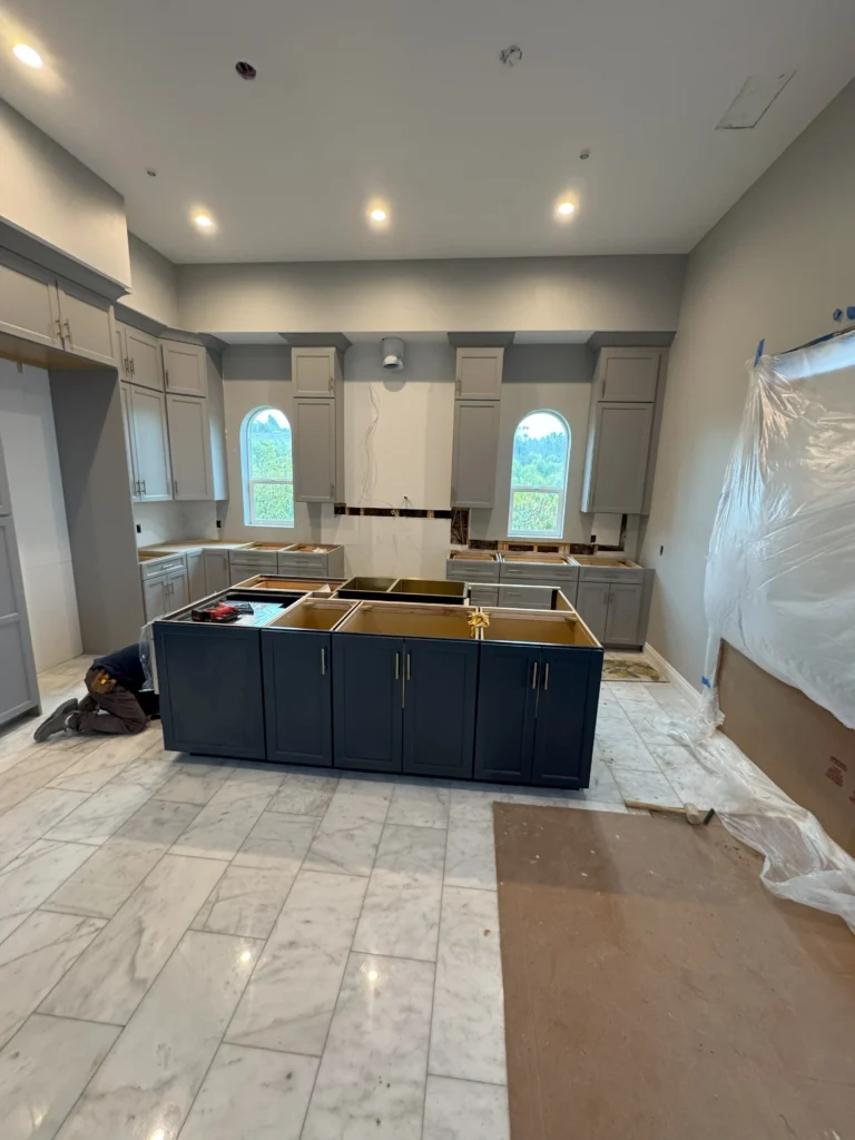 grey kitchen cabinets with navy blue island and gold hardware