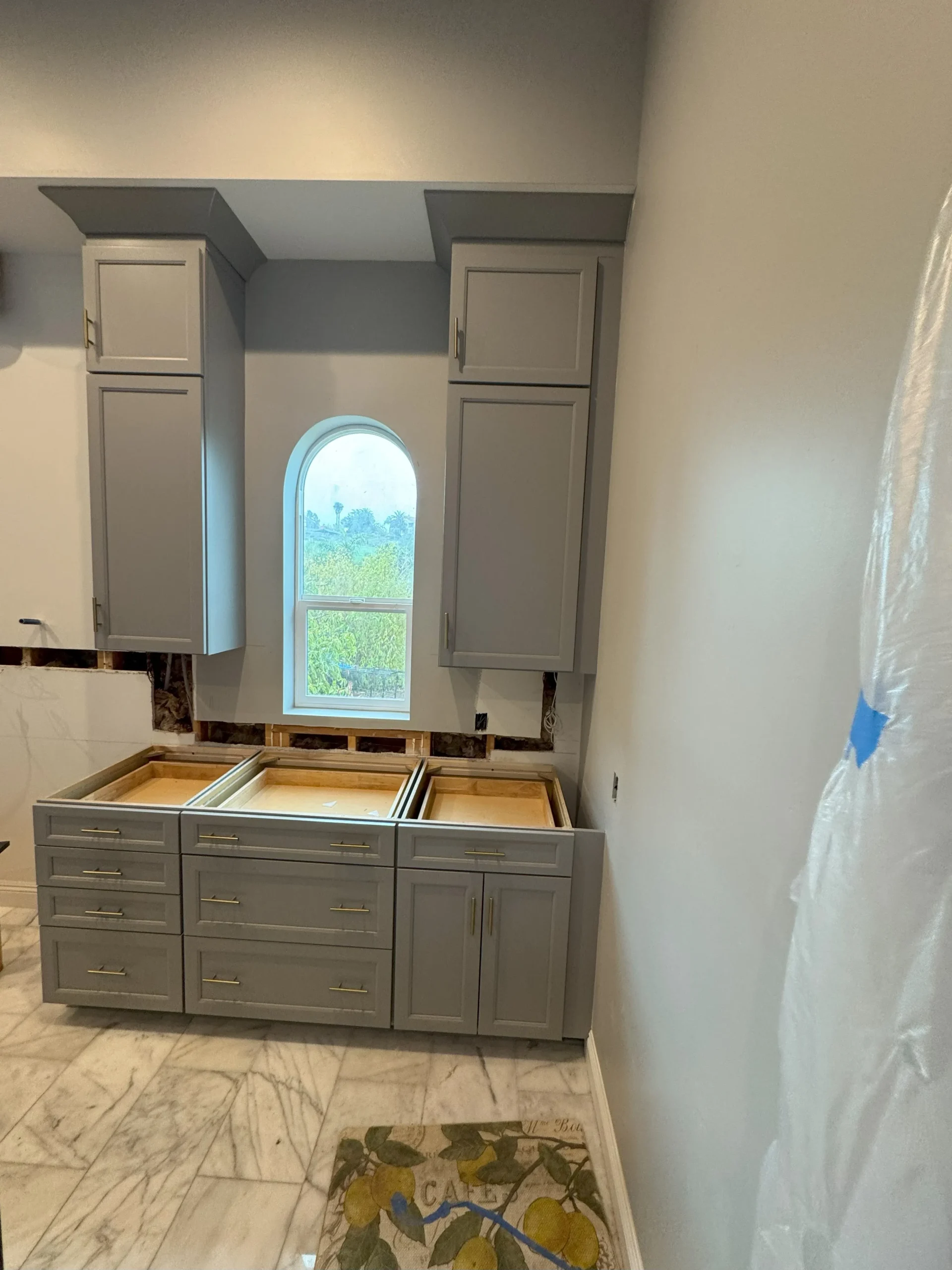 grey kitchen cabinets with navy blue island and gold hardware