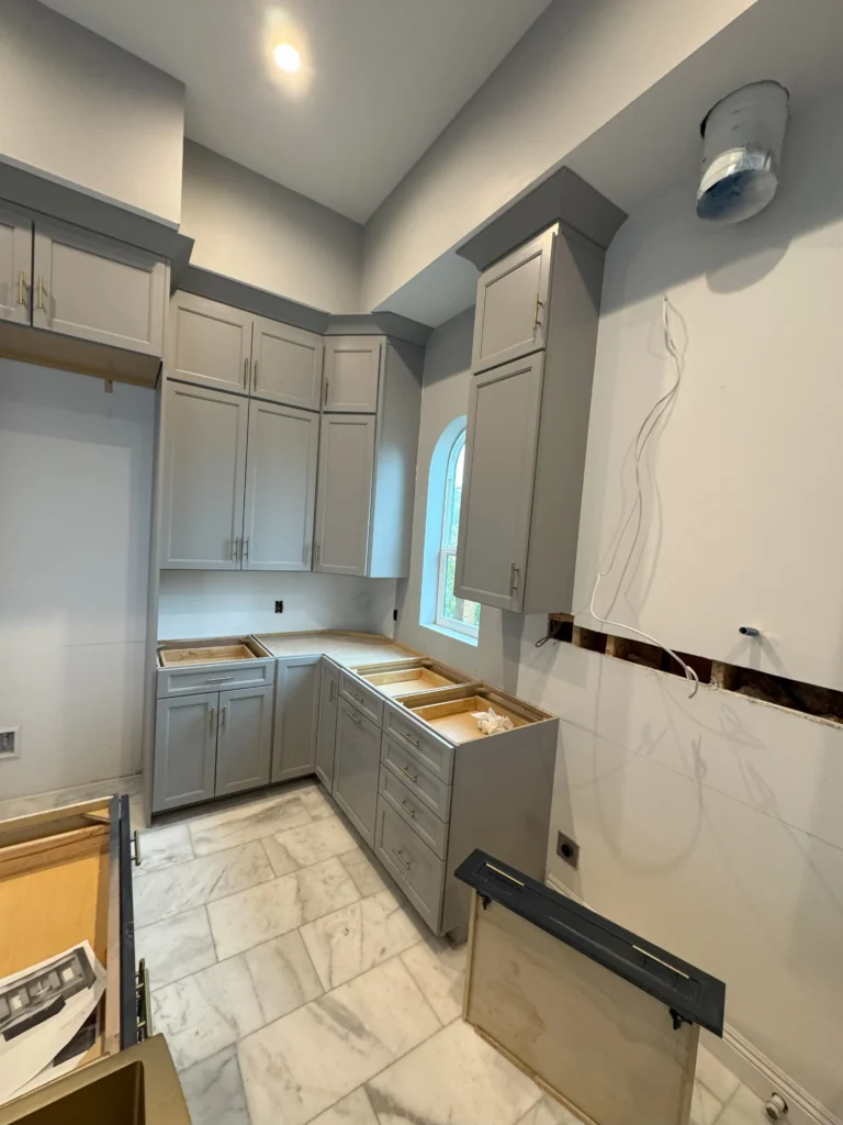 grey kitchen cabinets with navy blue island and gold hardware