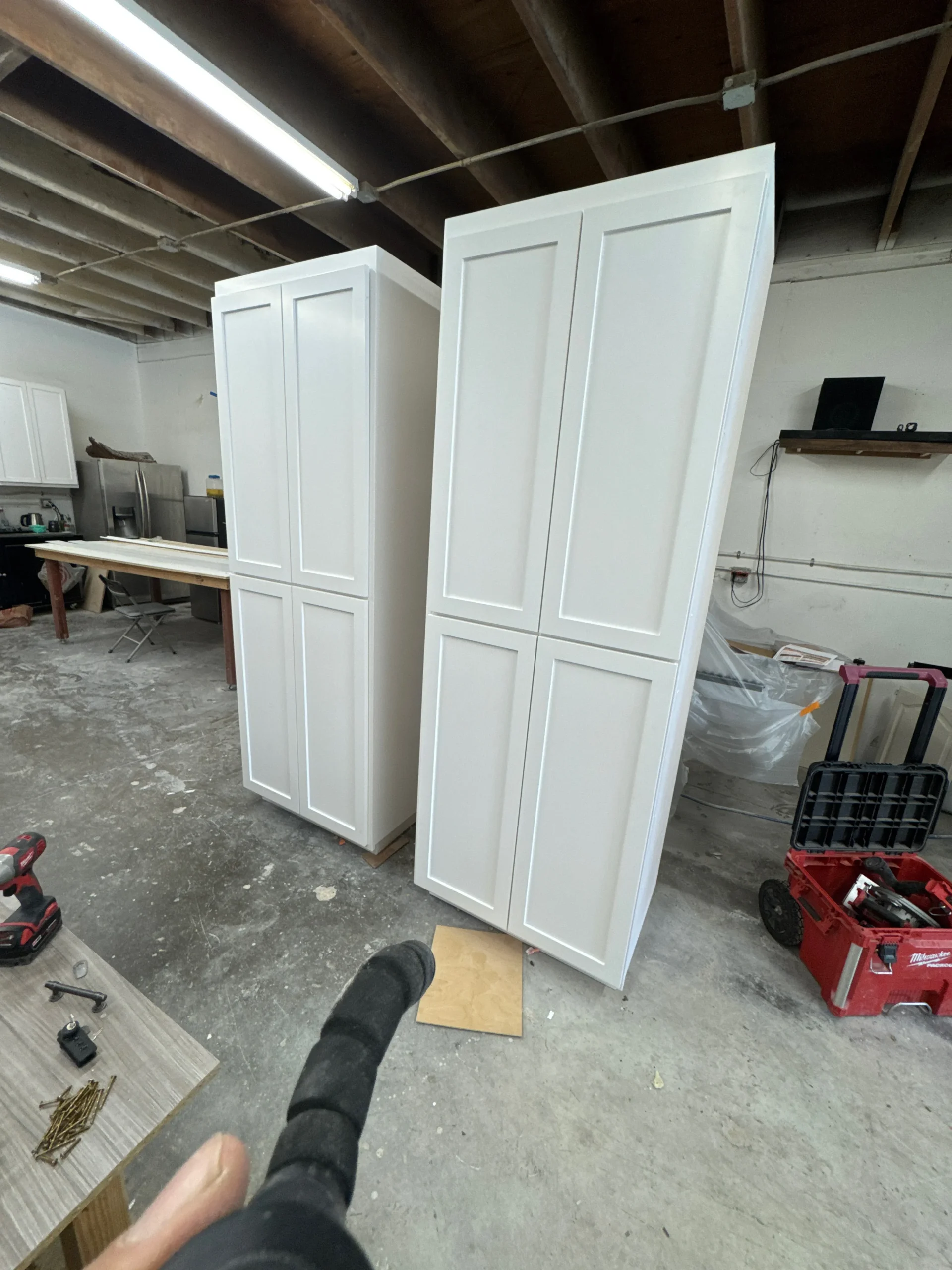 floor-to-ceiling white shaker style storage cabinets