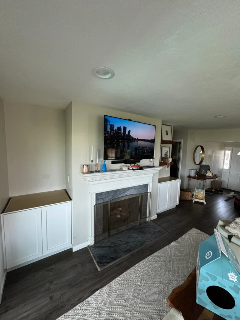 white handleless shaker cabinets flanking a fireplace